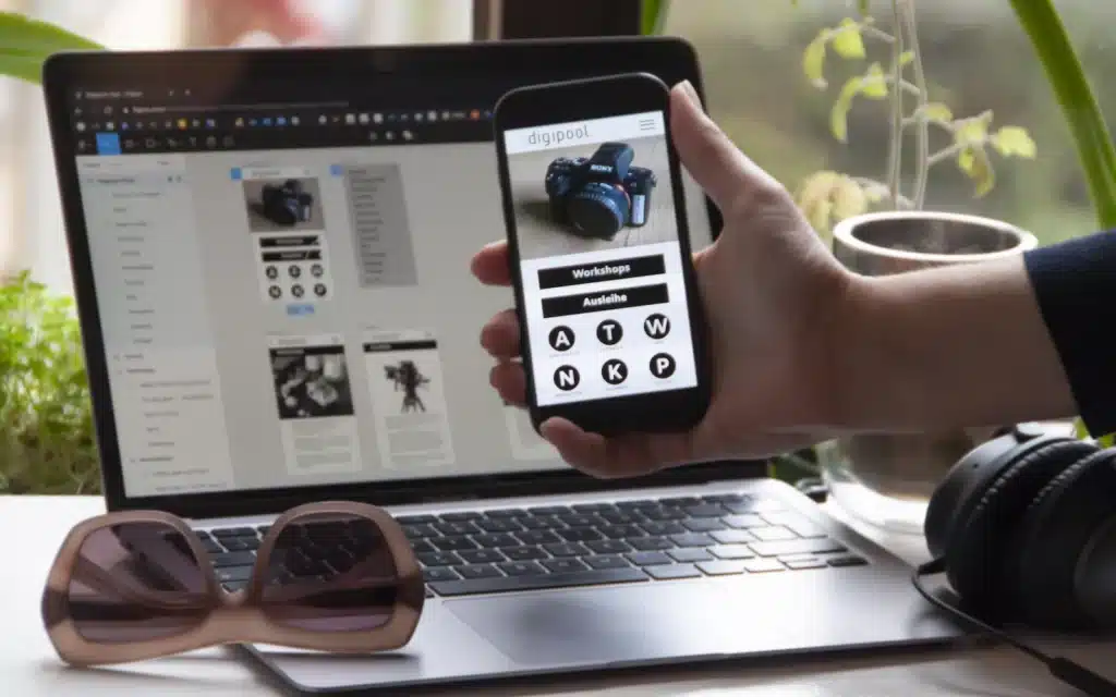 Smartphone mit App vor einem Laptop